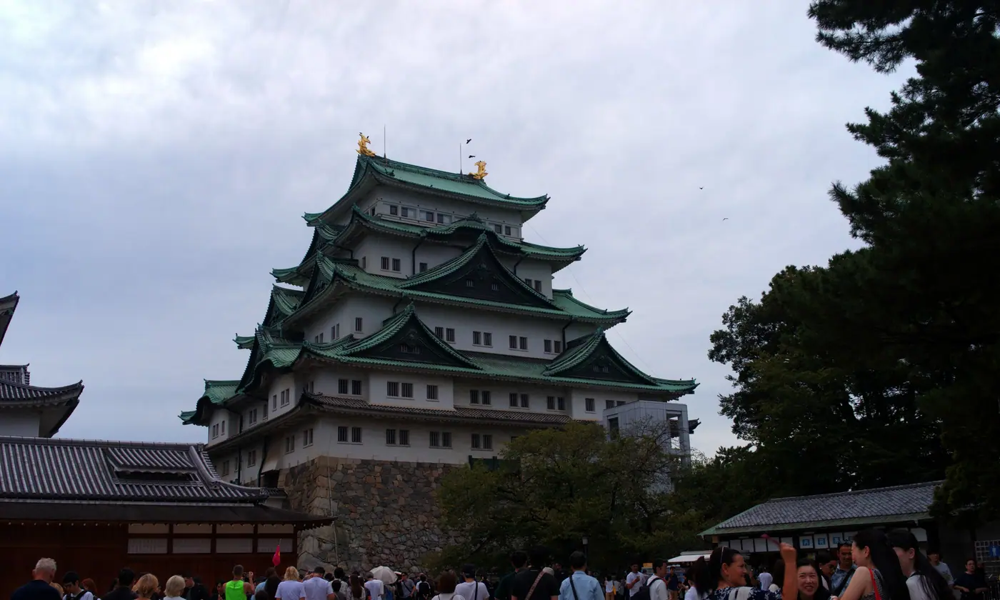 Nagoya Castle's main keep and its golden shachihoko under a cloudy sky