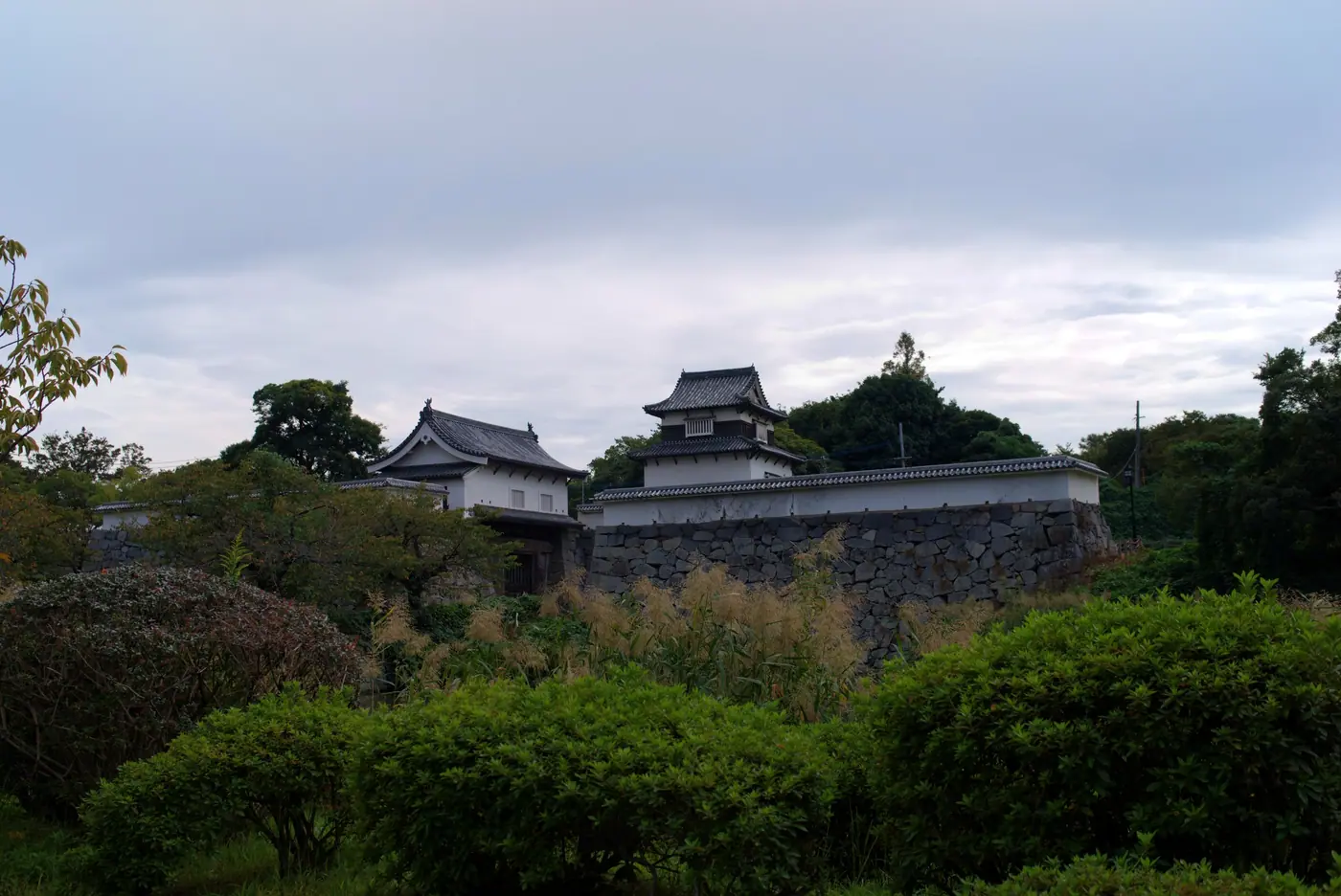 Turrets above the stone walls of Fukuoka Castle, seen across the gardens