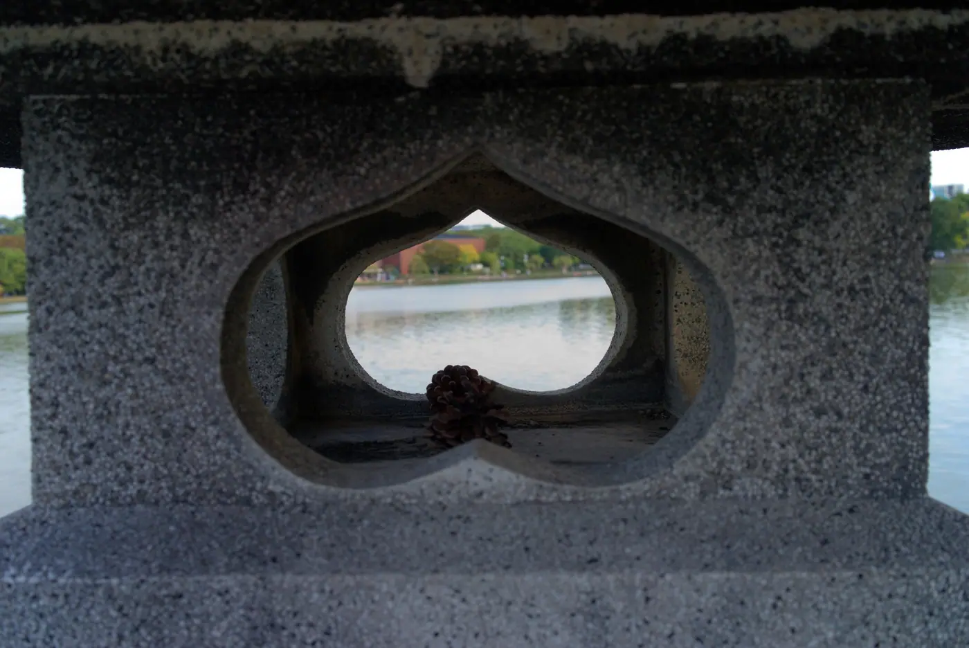 The lake at Ohori Park framed by a heart-shaped opening in a stone lantern