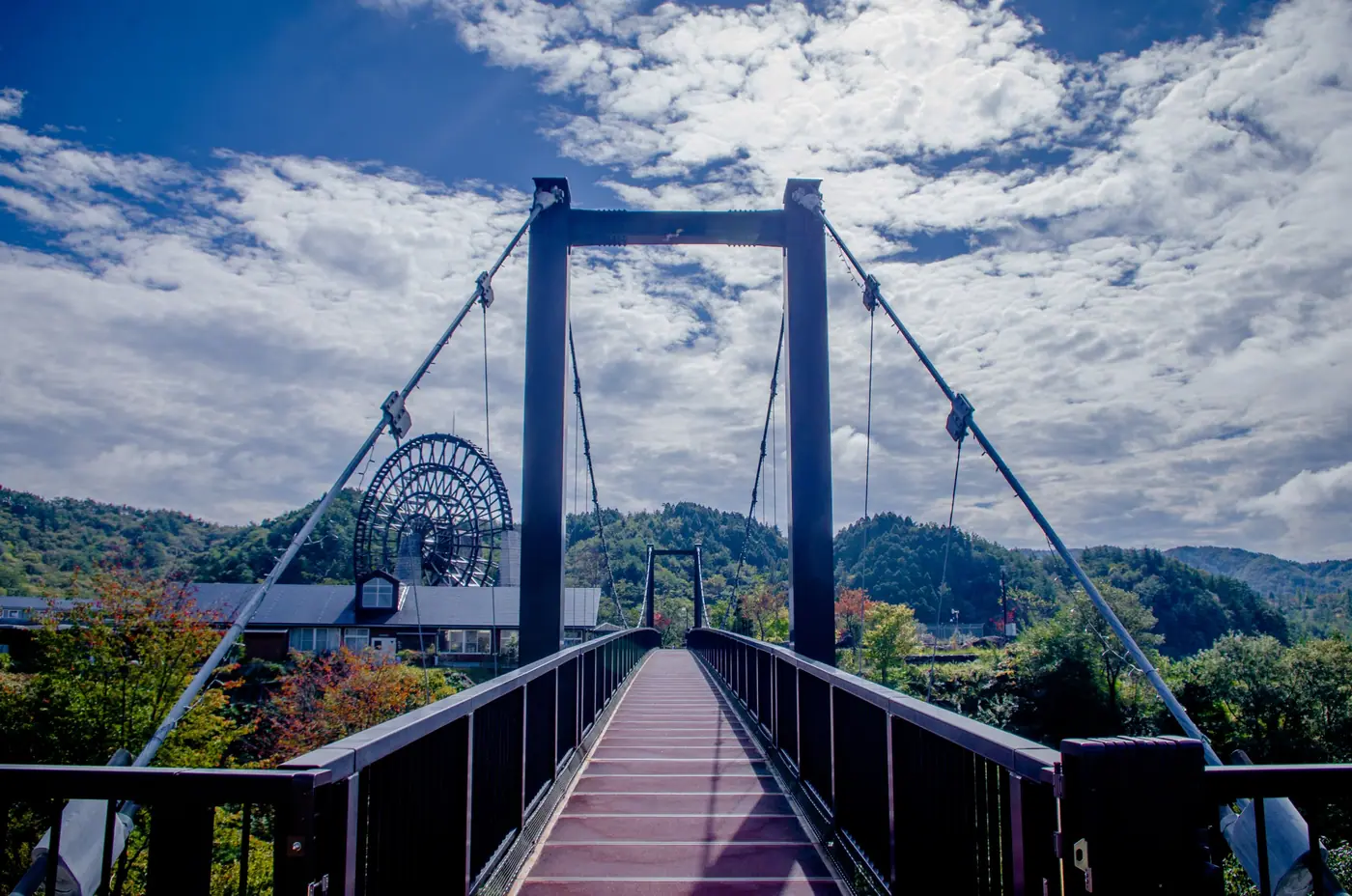 Walking across the suspension bridge toward the waterwheel
