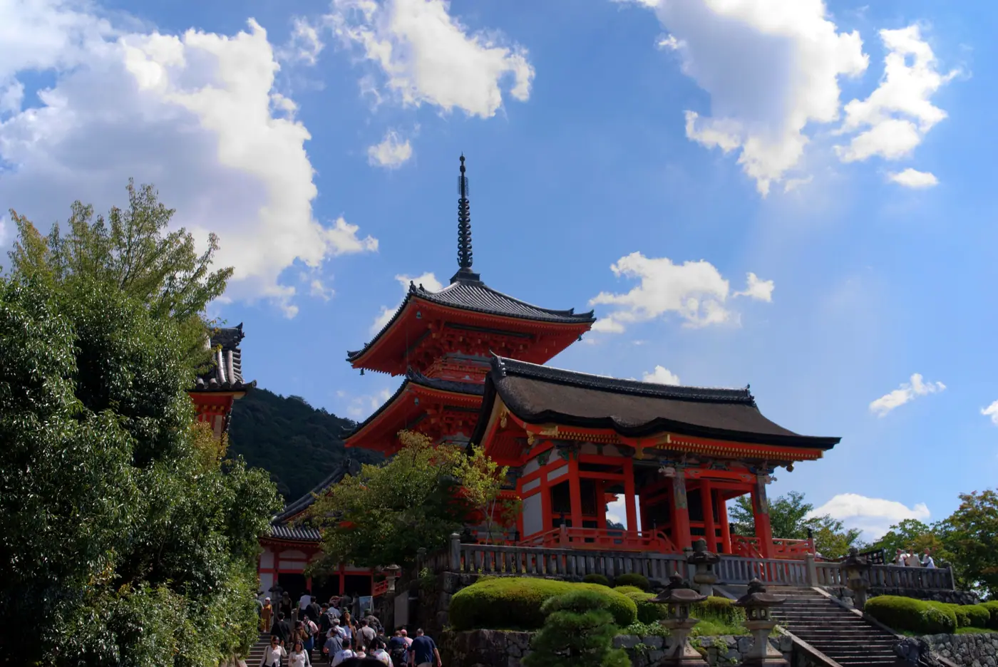 The west gate and three-story pagoda of Kiyomizu-dera under a blue sky